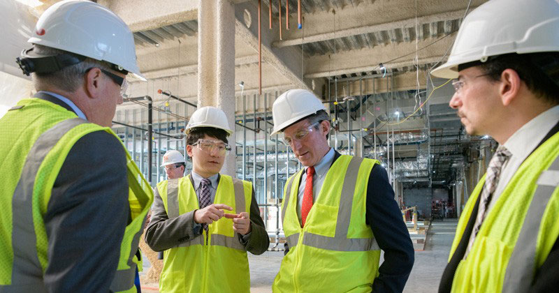Kelvin Lee, director of the National Institute for Innovation in Manufacturing Biopharmaceuticals (NIIMBL) and Gore Professor of Chemical Engineering at UD, answers questions from Delaware Gov. John Carney during a tour of the Ammon Pinizzotto Biopharmaceutical Innovation Center, under construction on UD's STAR Campus. On the far left is Jeff Garland, vice president and University secretary, and on the far right is John Koh, director of the Delaware Biotechnology Institute.